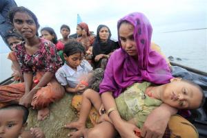 Rohingya refugees from Myanmar sit on a boat as they try to get into Bangladesh in Teknaf